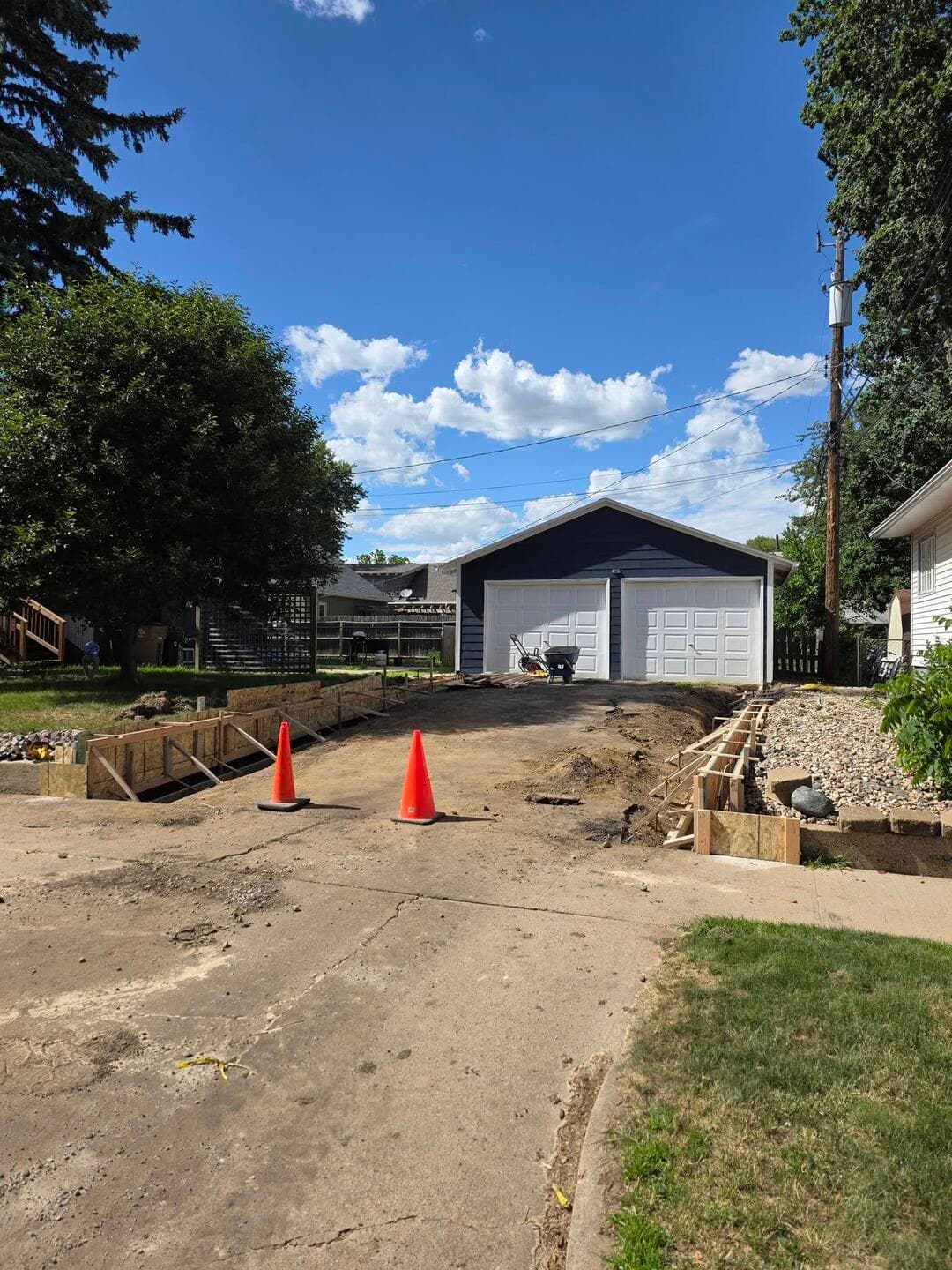 The driveway strip torn out, graded, and formed with cones set, ready for base and rebar