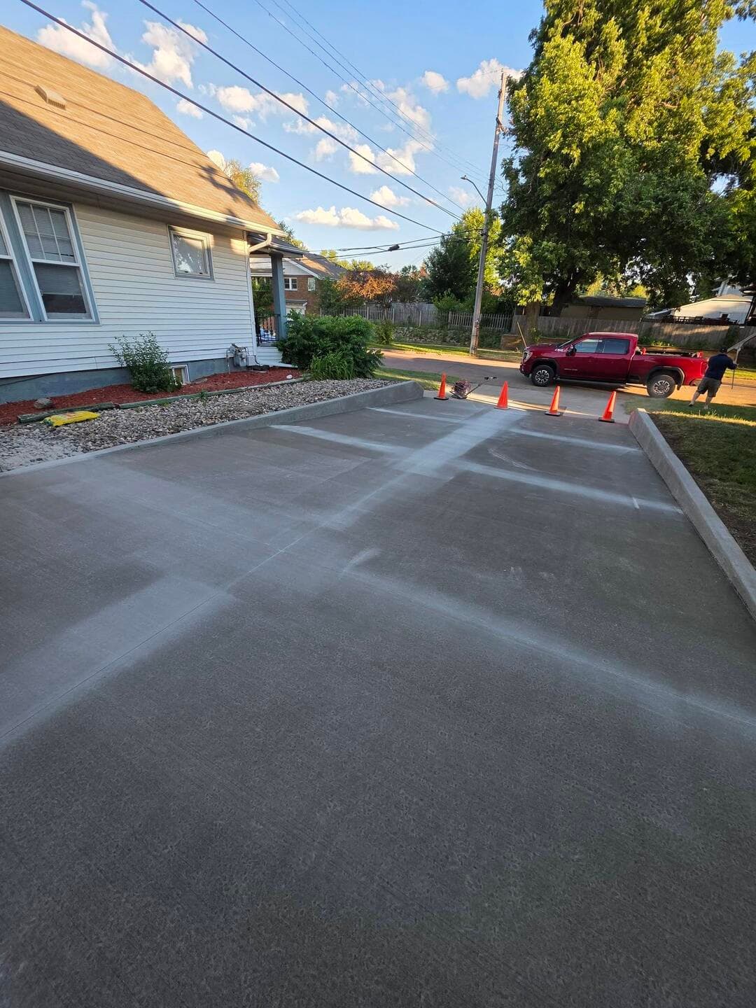 A fresh broom-finished driveway curving past the corner of a Sioux Falls home