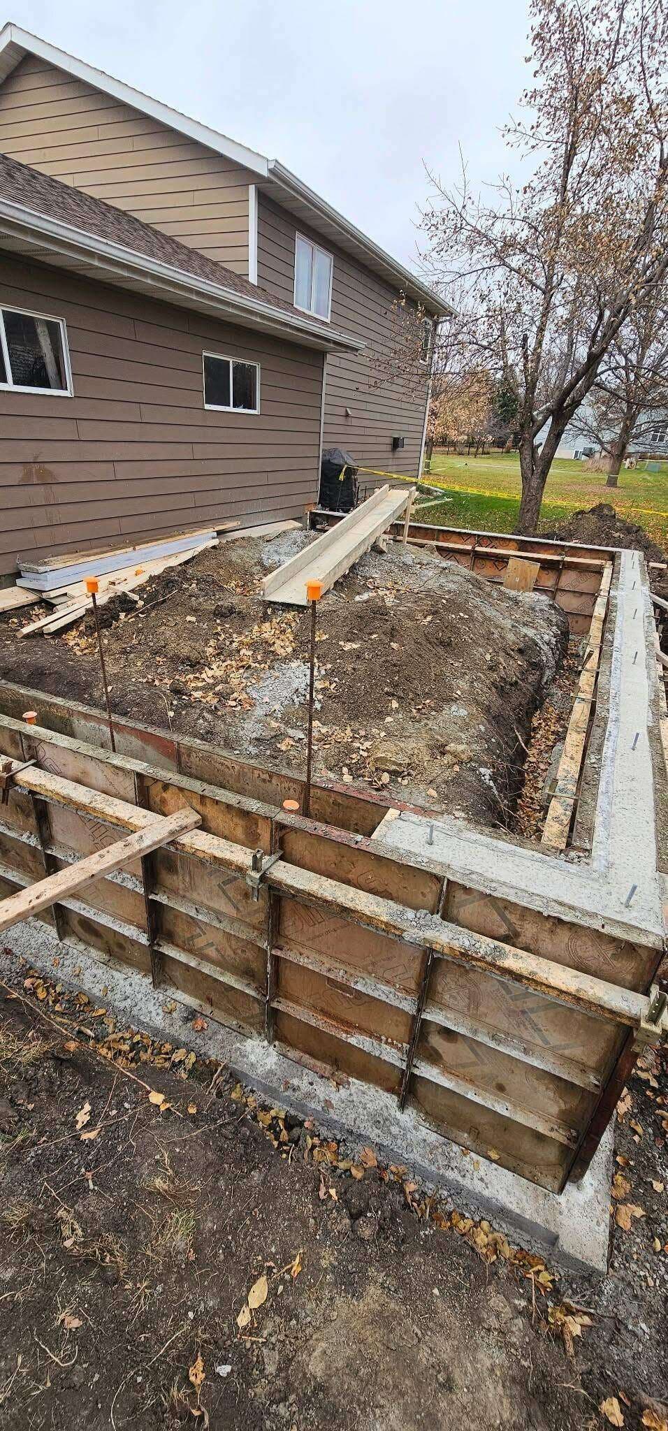 Plywood foundation forms staked and braced over a poured footing at a home addition