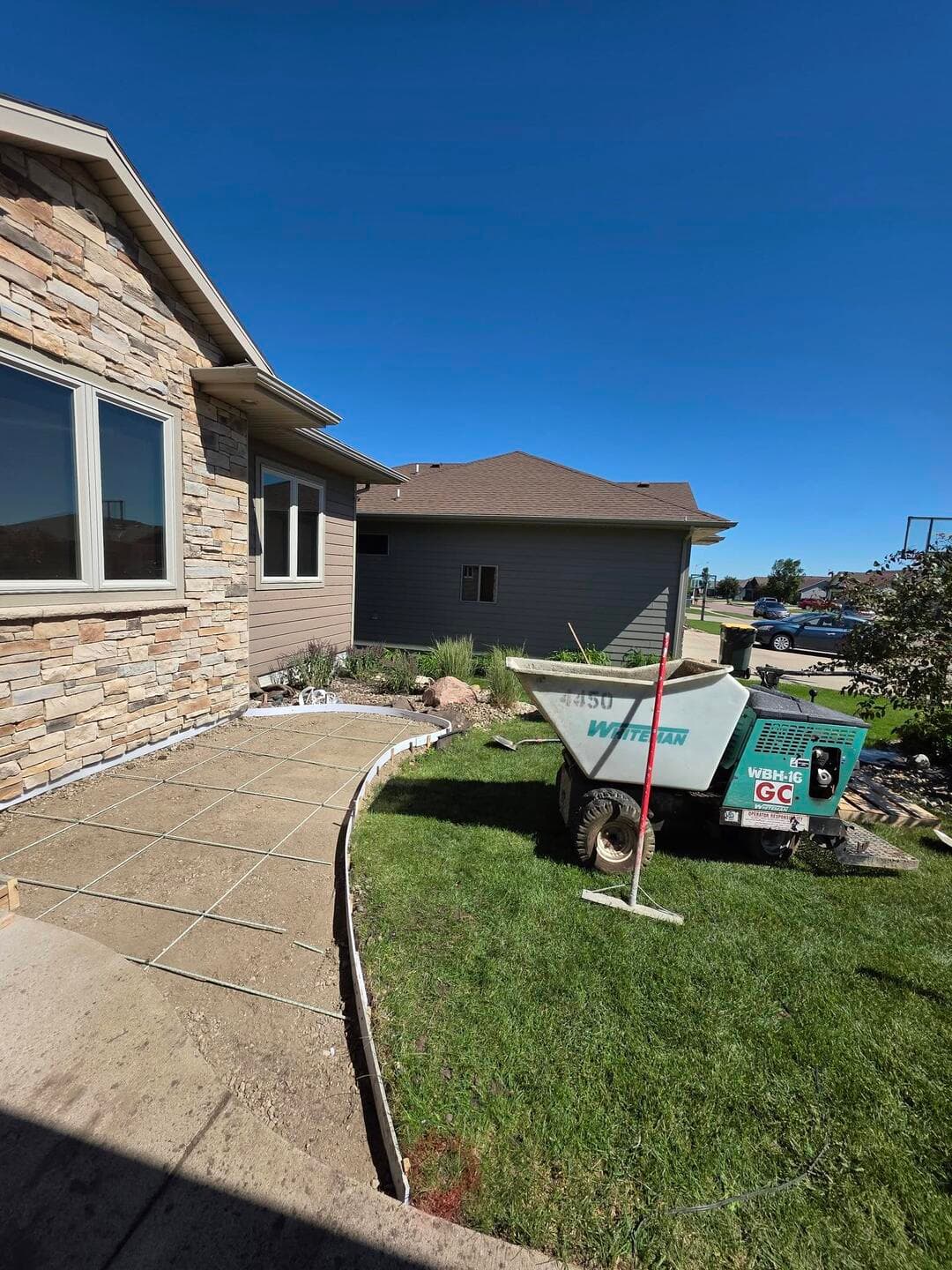 A freshly scored backyard patio, our GC concrete buggy still parked on the lawn