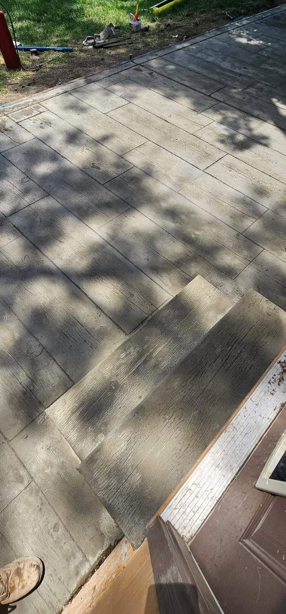 Wood-plank stamped concrete walk and step at an entry, plank grain pressed into the finish
