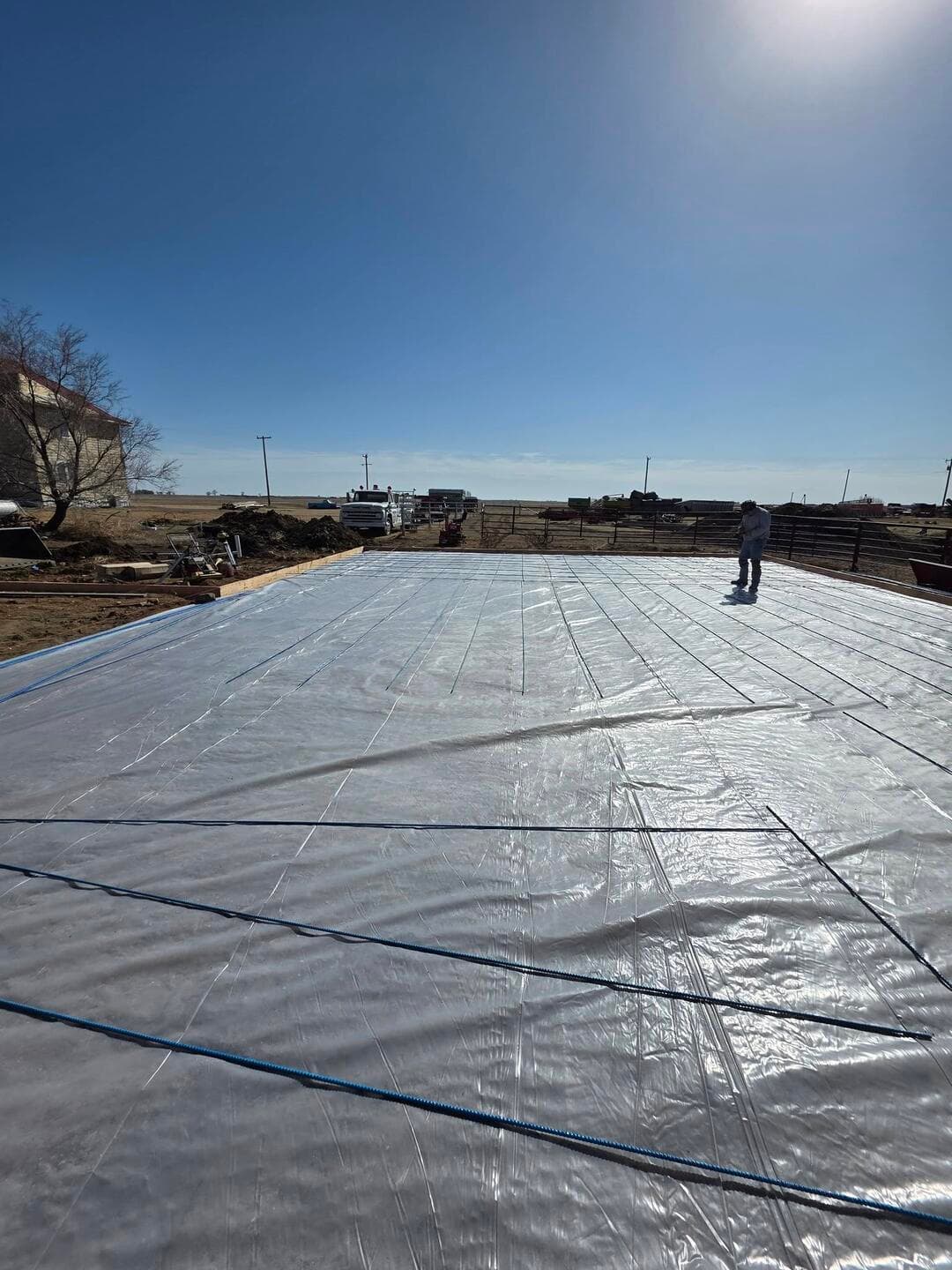 Vapor barrier sheeted and rebar going down across a large formed pad